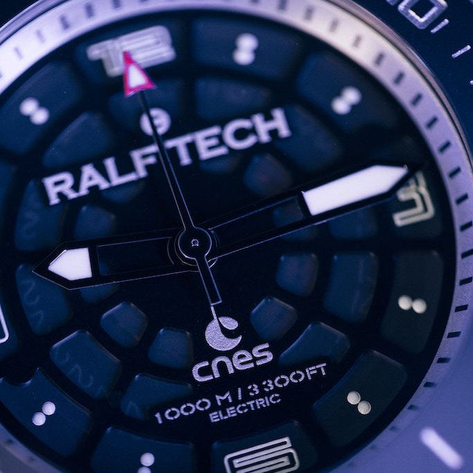 Zifferblatt der RALF TECH WRX Electric Supernova Millenium x CNES in Nahaufnahme, Wabenstruktur mit CNES-Signet und Kennzeichnung 1000 M / 3300 FT ELECTRIC