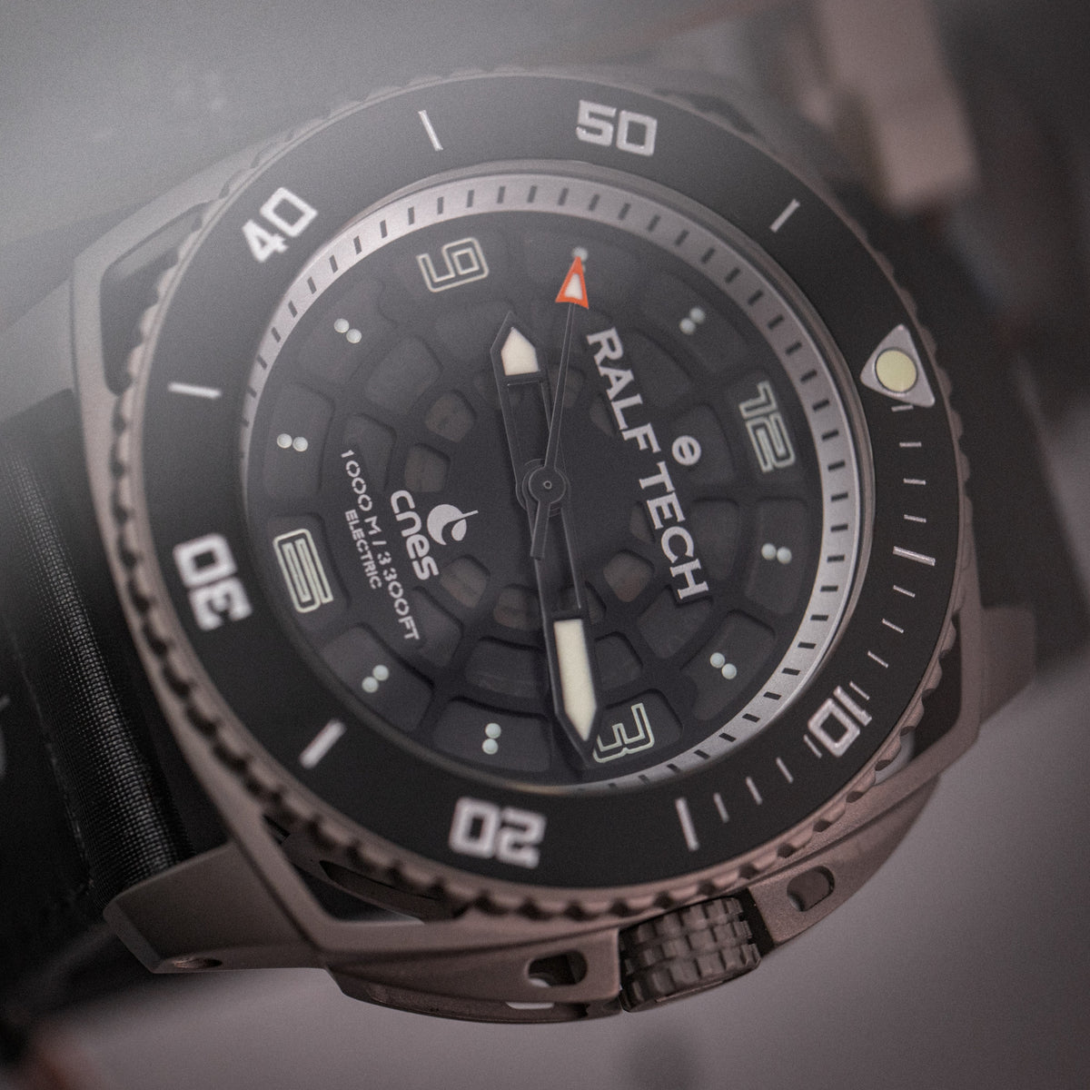 RALF TECH WRX Electric Supernova Millenium x CNES frontal in gedämpftem Licht, Titangehäuse mit schwarzer Lünette und Wabenzifferblatt